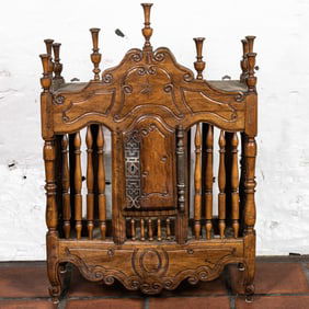 An antique French Provincial walnut panetiere circa 1790, the scrolled crest surmounted by urn-form