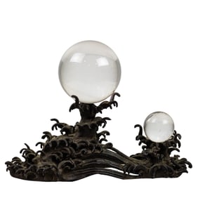 A Japanese bronze wave-form stands with two glass spheres