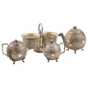 A four-piece Indian silver repousse tea set