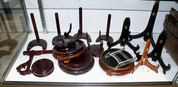 A group of approximately seventeen display easels and vase stands
