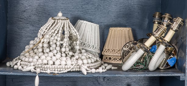 A Restoration Hardware white beaded light fixture and two pairs of wrapped sconces with wicker
