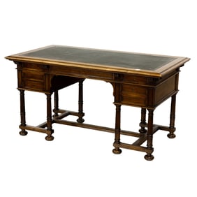 A Henri II style leather mounted oak kneehole desk
