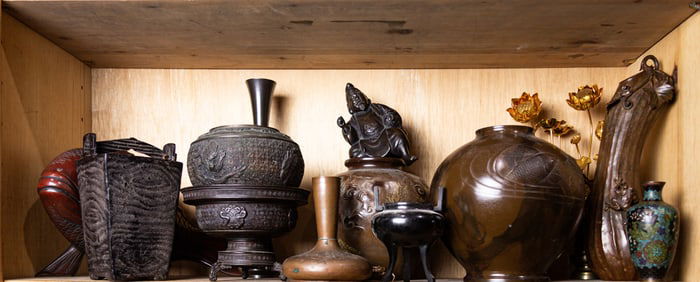 A shelf of Japanese decorative metal objects