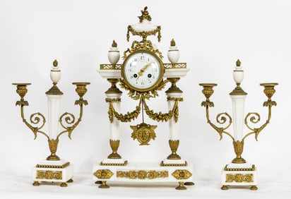 A Neoclassical style gilt bronze mounted marble three-piece clock garniture