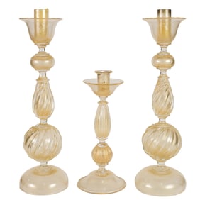 A suite of three Murano gold flecked glass candlesticks
