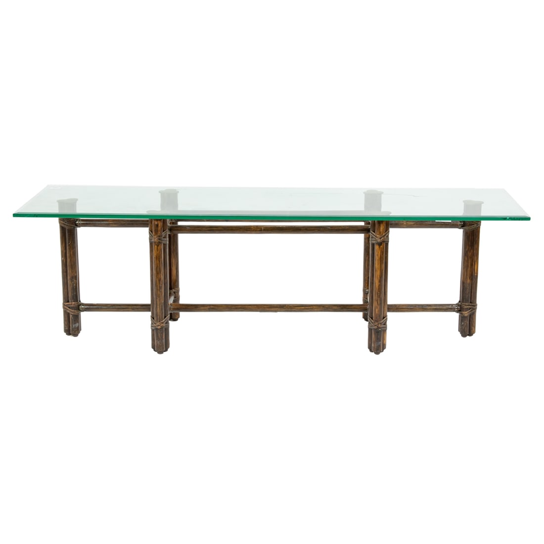 A McGuire rattan and glass top low table: A McGuire rattan and glass top low table, the long rectangular glass top with beveled edge, metal factory tag, 15.5"h x 55"l x 16"d