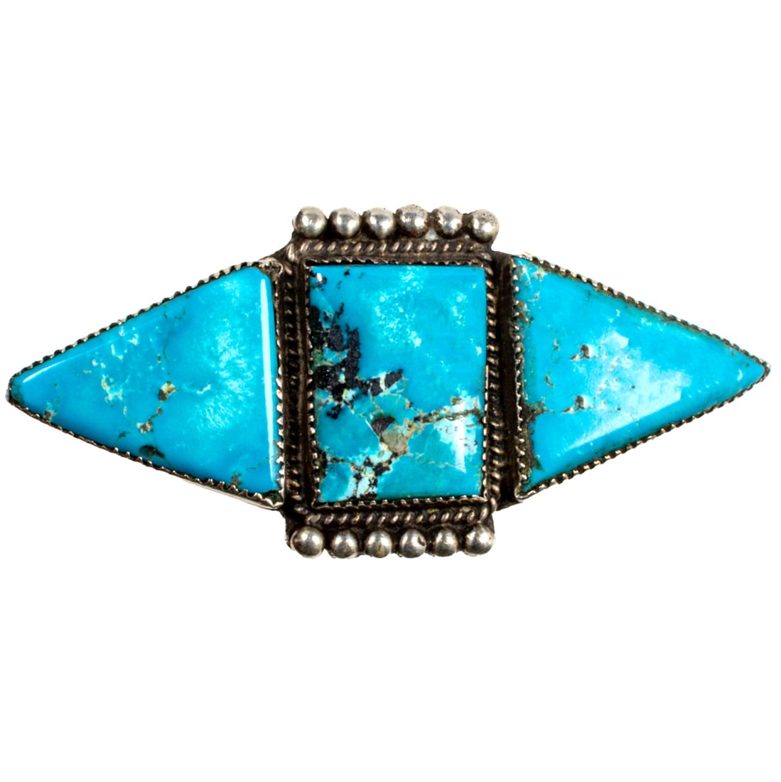 A Native American turquoise and silver ring: A Native American turquoise and silver ring Centering a rectangular turquoise cabachon measuring approximately 18.1 x 23.7 mm, framed on either side by triangular turquoise cabachons measuring approxi