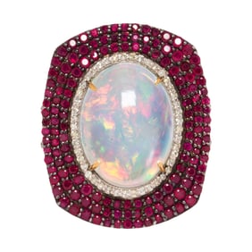 An opal, ruby, silver, and 14k gold ring