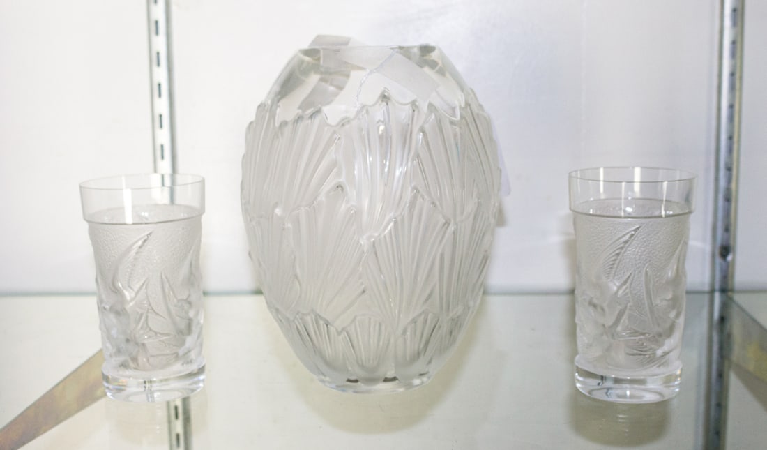 A group of Lalique glass: A group of Lalique glass, comprising a Sandrift vase, 8"h and a pair of tumblers molded with swallows, 5"h [3 total]
