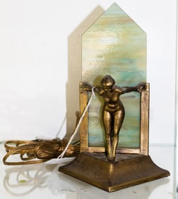 An Art Deco patinated metal and slag glass figural night light