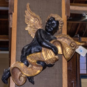 A Venetian Rococo style painted and parcel gilt composition figure of a putto