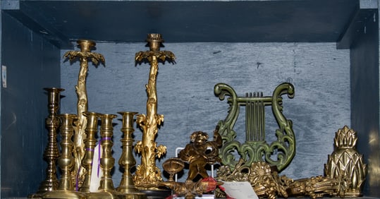 A group of mainly brass candlesticks and curtain tie backs