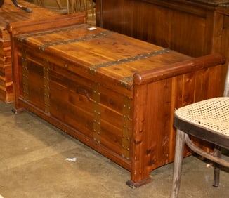 A cedar chest with copper straps and nailhead trim