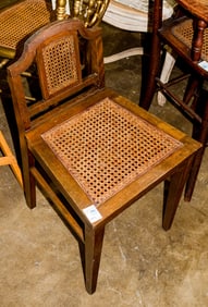 A telephone chair with caned seat and backrest