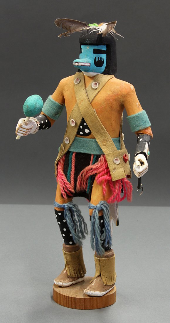 Hopi Kachina, circa 1950: Hopi Kachina, circa 1950. "Blue Bear" made of carved wood, shells, leather, yarn, and polychrome pigment. Doll with feathers surmounting a blue face with muzzle and holding a rattle. The whole rising