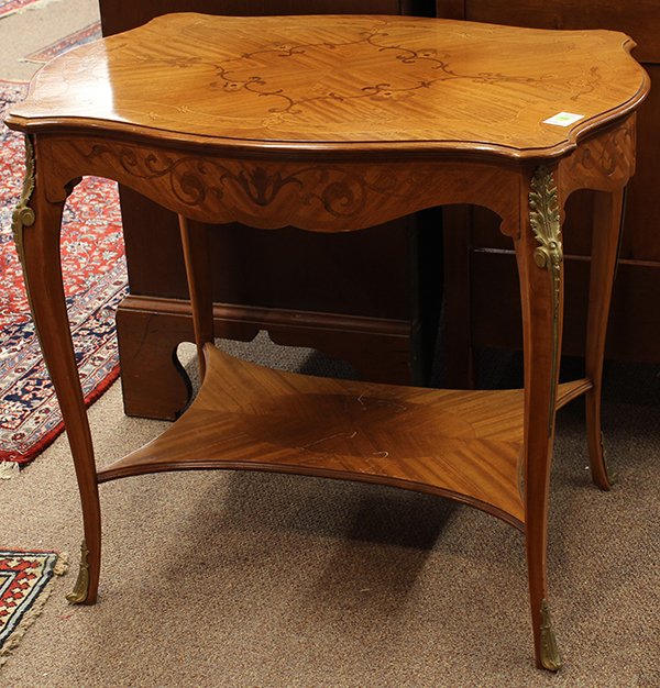 Louis XV style occasional table: Louis XV style occasional table, the marquery decorated top with floral sprays continuing to the conforming border, above the inlaid apron and rising on gilt bronze mounted cabriole legs terminating o