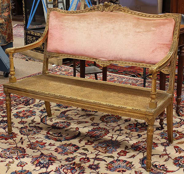 Louis XVI style giltwoood carved settee: Louis XVI style giltwoood carved settee, early 20th century, having a serpentine padded back centering the carved frame accented with bellflower reserves, the turned arm returns terminating at the can