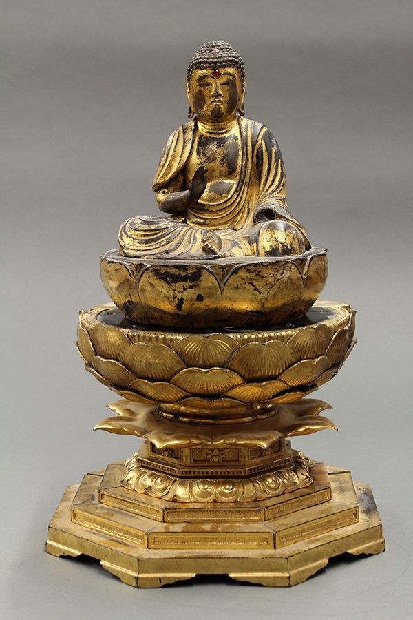 Japanese Gilt Wooden Buddha ,19th Century: Japanese gilt lacquered wooden statue of a Buddha, 19th century, draped in monastic robes and with his hand in abhaya mudra, seated on a double lotus pedestal set on a stepped base (lacking one hand),