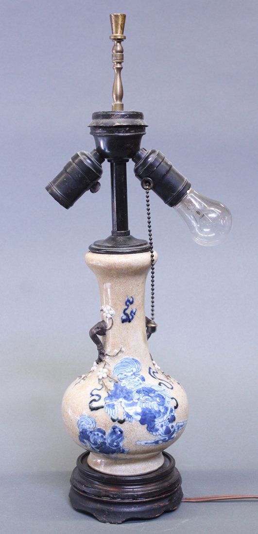 Chinese Stick-neck Porcelain Vase/Lamp, Lions: Chinese underglaze blue stick-neck vase, now mounted as a lamp, with a wheat colored crackle glaze ground decorated with a fu-lion and cub in cobalt blue, the cylindrical neck flanked by branch form h