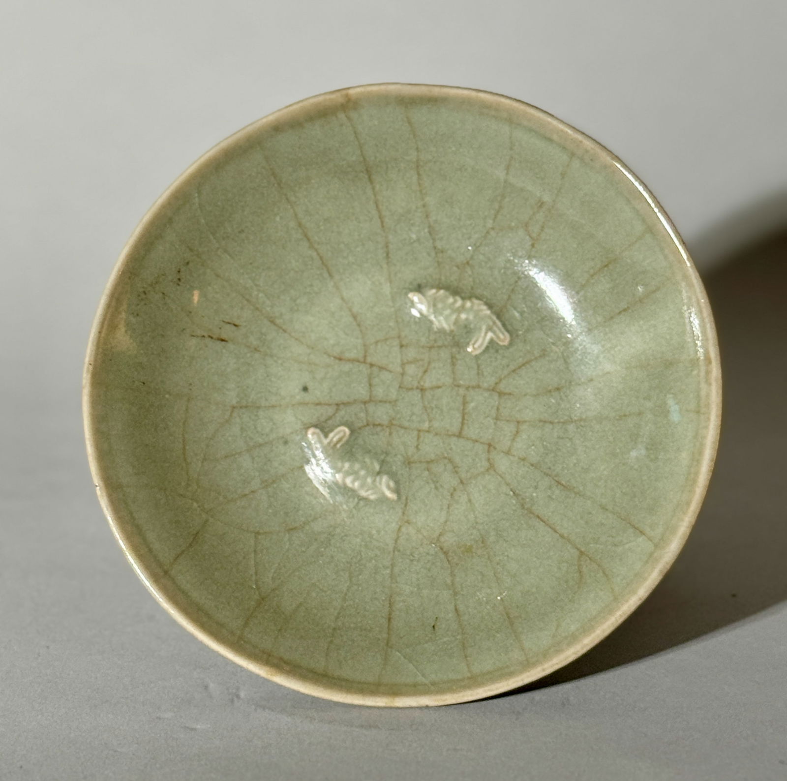 Chinese Celadon Porcelain Dish with Twin Fish: Chinese celadon porcelain dish with molded twin fish design. 6"dia (15.24 cm) NOTE: THIS ITEM IS IN OUR NEW YORK, WHERE IT CAN BE SHIPPED FROM.