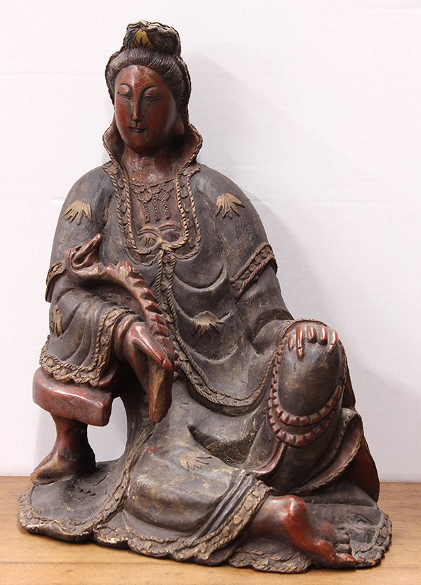 Chinese Lacquered Wood Guanyin: Chinese gilt lacquered wood carving of Guanyin, draped in robes accented with bamboo leaves and seated in laliasana while holding a ruyi scepter, 20.75"