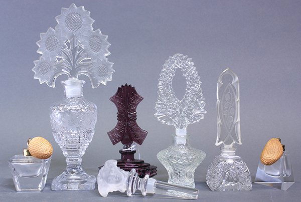 Scent bottles and Versace figural stopper: (lot of 7) Vintage Continental style crystal scent bottles including a large frosted to clear glass example with sunflower motif; together with a Versace frosted figural stopper, tallest: 10.5"h