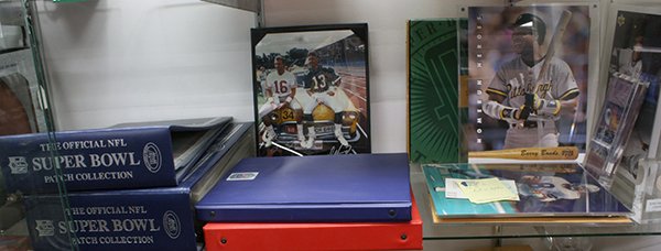 Sports memorabilia: One shelf of sports memorabilia including Official NFL Super Bowl Patch Collection from 1967 to 2010, photographs of sports players, some autographed including Brent Jones, Dwight Clark, Ted Kwalick, 