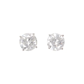A pair of diamond and 14k white gold solitaire earrings