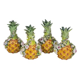 A set of four Jacob Petit porcelain floral encrusted pineapple bottles