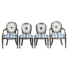 A set of four ebonized and parcel gilt dining chairs