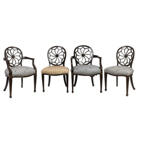 A set of four ebonized and parcel gilt dining chairs