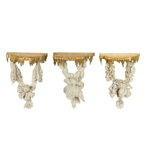 A set of three Regency style painted and parcel gilt wall brackets