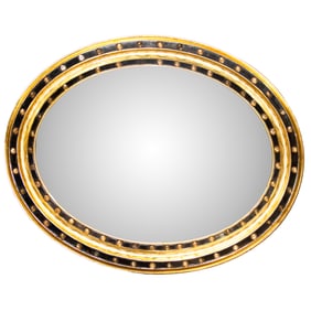 A Irish glass cabochon mounted parcel gilt and ebonized oval mirror
