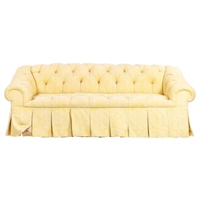 A tufted sofa in the Chesterfield style upholstered in muted yellow jacquard fabric