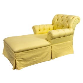 A tufted chaise lounge in pale yellow canvas upholstery