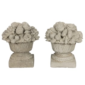 A pair of cast stone fruit and flower filled baskets