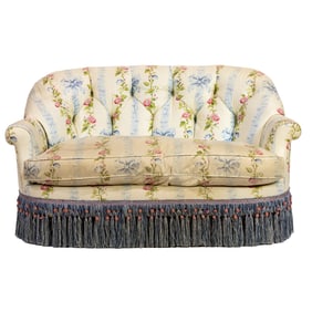 A settee upholstered in pale blue ribbons with alternating bands of morning glories on a cream