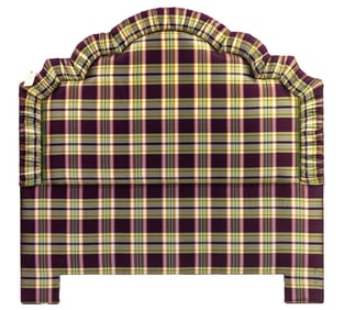 An aubergine and green plaid upholstered headboard and various linens