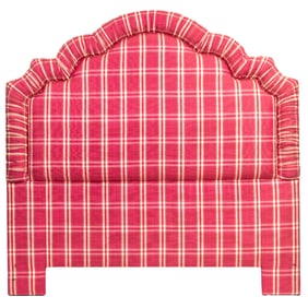 A pink plaid upholstered headboard with various bedding and curtain panels