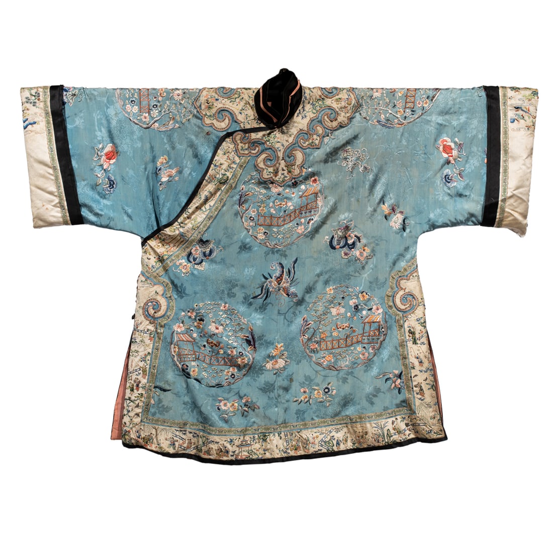 A Chinese blue-ground embroidered silk lady's informal robe: A Chinese blue-ground embroidered silk lady's informal robe. Decorated with roundel of garden setting design, amidst butterflies and flowers, the collar and trimming decorated with continuous scene of