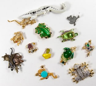 Thirteen costume jewelry brooches of frogs and lizards
