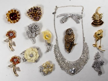 Fourteen Nolan Miller costume jewelry brooches with a Nolan Miller necklace