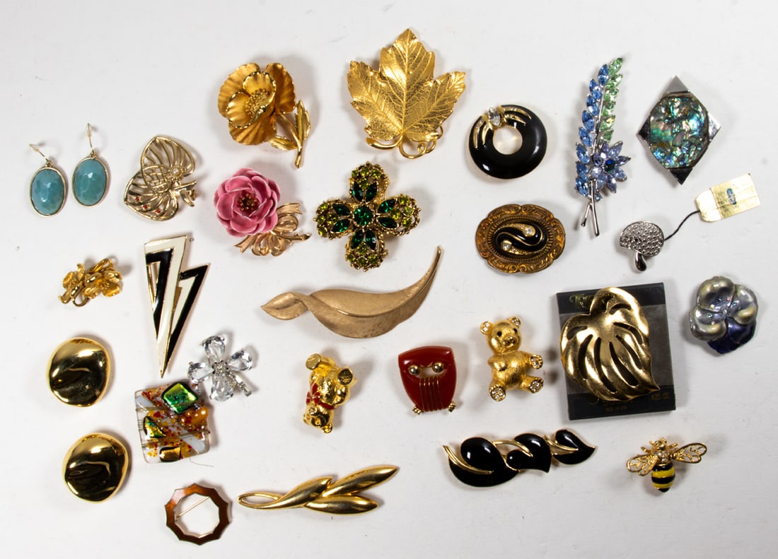 Sixteen Trifari costume jewelry brooches, (2) pairs of Trifari earrings with eight additional pieces: Sixteen Trifari costume jewelry brooches, (2) pairs of Trifari earrings with eight additional pieces by various makers. [26 total]