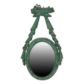 A Neoclassical style green painted oval mirror suspended from a ribbon tied with trophy to love