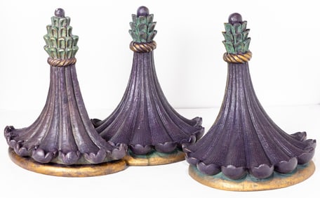 A set of three painted and parcel gilt cast stone wall brackets