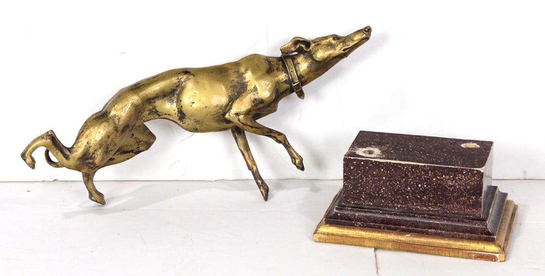 A gilt metal figure of a whippet with faux marbleized plinth base: A gilt metal figure of a whippet with faux marbleized plinth base, presently separated from base, 18.5"h overall. Provenance: The Carole Harris Collection, River Ranch. The interiors guided by Parish-