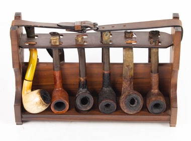 A group of twelve pipes in wood stand with leather strap
