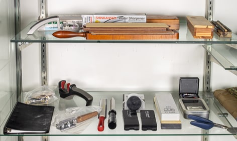 Two shelves of knife sharpening tools and whet stones, including CRKT Slide Sharp knife sharpening