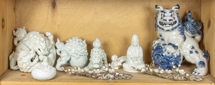 A shelf of Japanese porcelain shishi and various figures