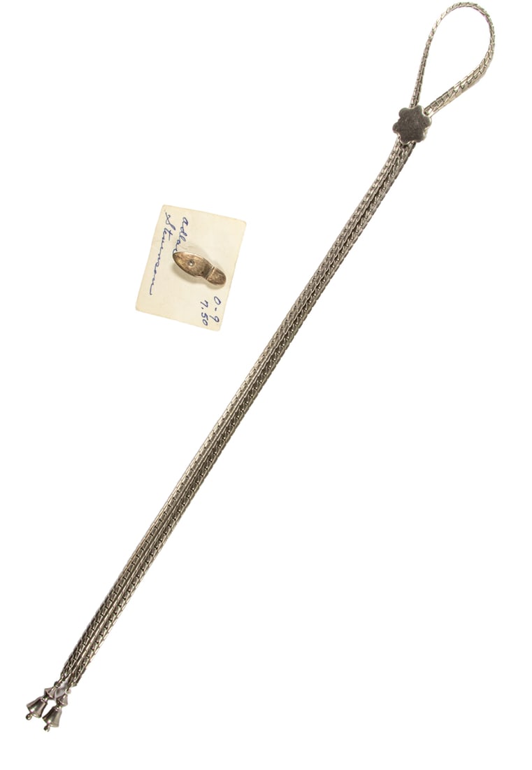 A silver bolo tie and pin: A silver bolo tie and pin The bolo tie designed with a sun, together with a footprint pin; bolo tie length: 14 in; pin length: 1 in; gross weight: 42.40 grams